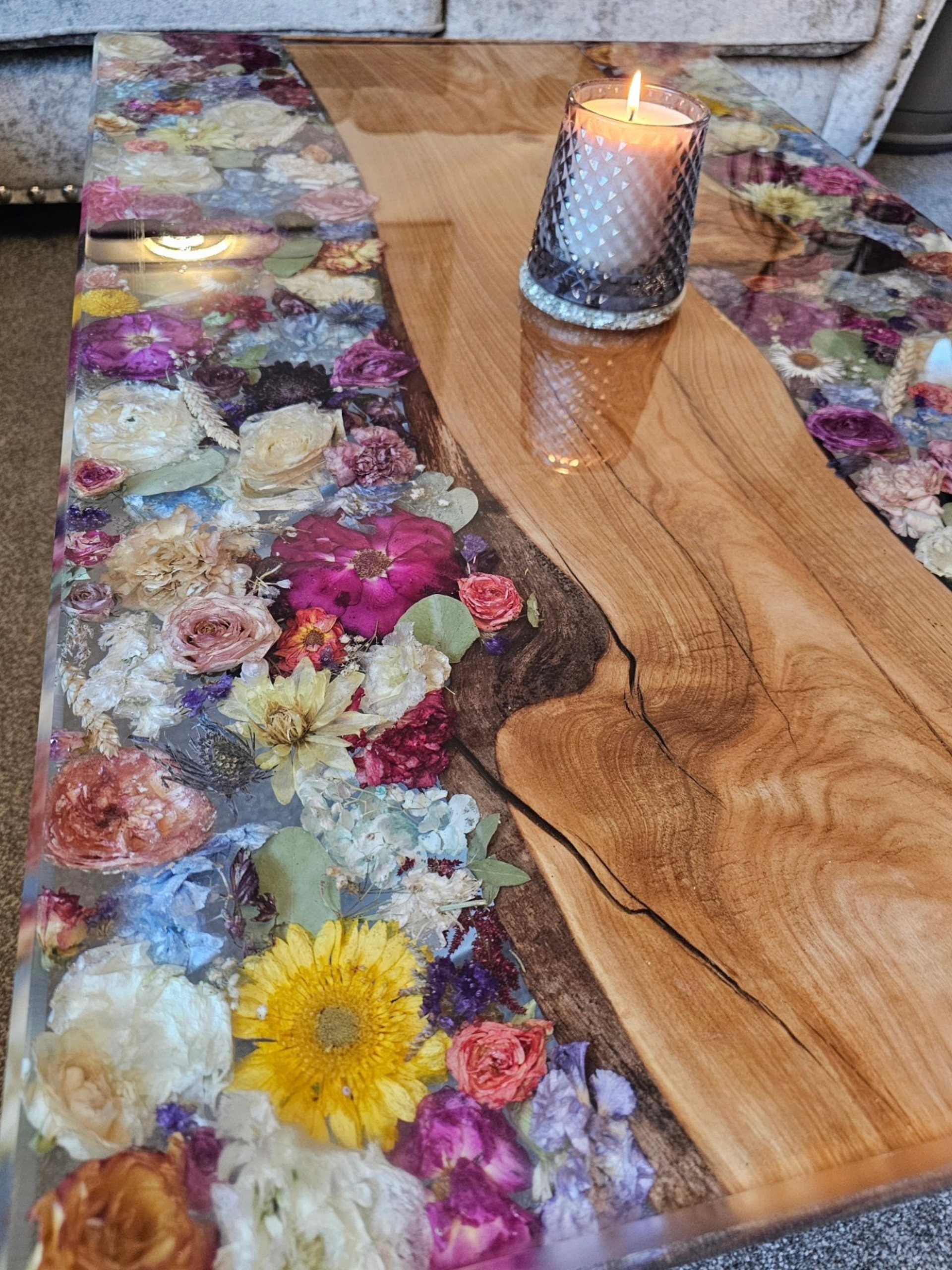 Handcrafted resin coffee table with preserved flowers from a wedding bouquet, showcasing vibrant blooms in a live-edge wood design.