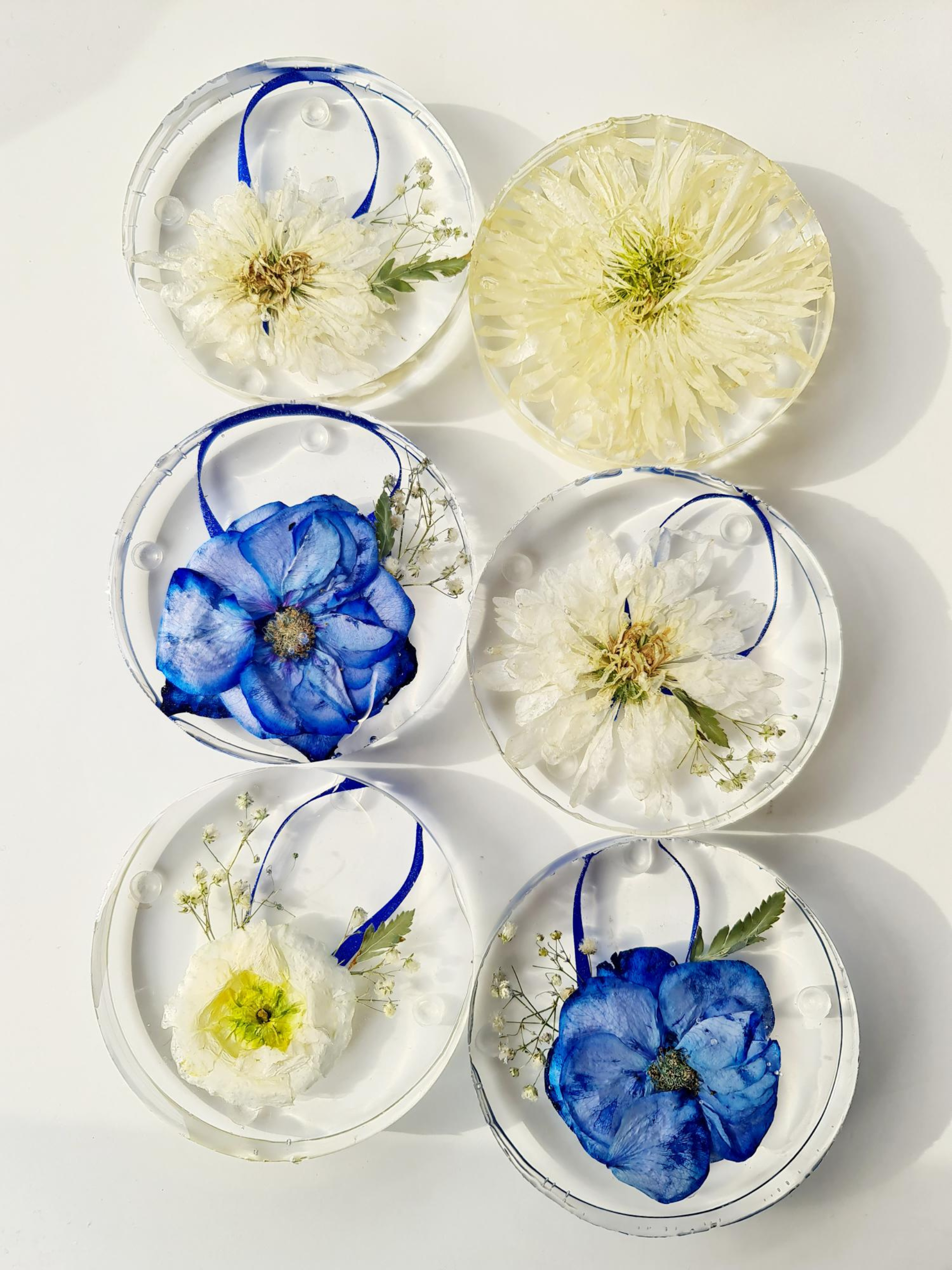 Round resin coasters with preserved blue and white wedding flowers